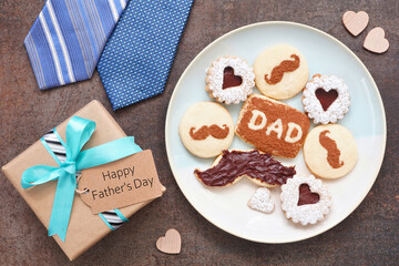 Aufkleber - Fathers Day table scene. Overhead view on a dark stone background. Plate of chocolate mustache, heart and dad cookies with gift box, ties and Happy Father's Day greeting card.