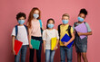 © Prostock-studio - Health care and education concept. Portrait of schoolchildren wearing protective masks against pink background