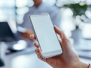 Poster - Closeup man holding a blank white screen smartphone in the living room home office desk