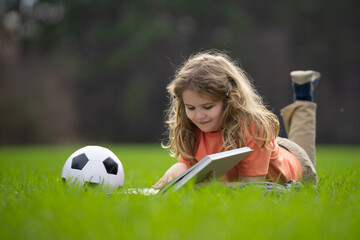 Aufkleber - Child reading a book in the grass. Kid enjoying a book story outdoors. Child studying with book in the meadow on a sunny day. Learning in nature. Schoolboy reading book in the park. Outdoor learning.