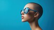 © Letitia - Profile of a young woman wearing blue sunglasses against a vibrant blue background.