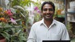 © Molang Visual - Smiling Man with Laptop in Greenhouse