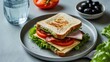 © Rizvan - Nutritious club sandwich featuring bacon, cheese, tomato, lettuce, and olives on a plate alongside a water glass, ideal for a healthy snack or meal. Top view.