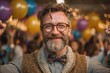© PhotoProd - Cheerful middle-aged man with glasses, beard and bow tie celebrating at festive occasion with balloons and crowd