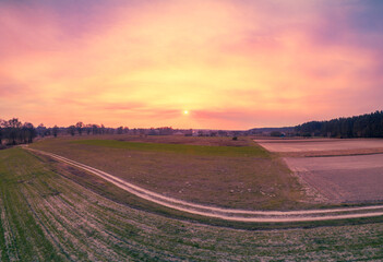 Wall Mural - rural landscape during sunset. view from above of plowed fields and country dirt road. nature landsc