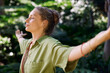 © Rido - Woman breathing deeply with outstretched arms in the middle of nature
