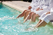 © Rido - Close up of feet splashing water at poolside