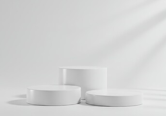 Poster - Three white cylindrical podiums arranged on a white surface with leaf shadow on the wall