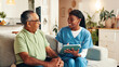 © FrameFlex/peopleimages.com - Nurse, senior man and tablet on sofa with smile for wellness, medical update and report in lounge. Woman, caregiver and elderly patient on couch with digital touchscreen, app and healthcare results