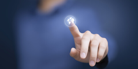 Fototapete - Hand of a person touching a digital globe icon, symbolizing global connectivity and technology, with a blurred blue background enhancing the futuristic atmosphere