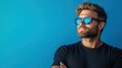© Freshpixel - A trendy young man with sunglasses poses confidently against a vibrant blue background, embodying a sense of coolness and summer vibe while exuding self-assured charm.