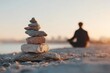 © Be i am - Zen stone stack symbol in foreground with blurred meditating figure, representing grounded balance, with warm tone, with a close-up perspective composition