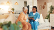 © peopleimages.com - Tablet, consultation and senior woman with nurse for medical discussion on sofa in home. Technology, conversation and caregiver explain with elderly patient, diagnosis and assisted living at house