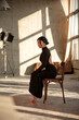 © Sergey - Brunette on a chair posing in a sunny studio