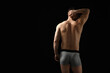 © New Africa - Young man in stylish light grey underwear on black background, back view. Space for text