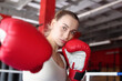© New Africa - Woman with protective gloves on boxing ring