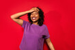 © ADDICTIVE STOCK - Woman laughing with hand on head against red background