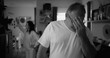 © Marco - Portrait of man with intense expression during argument, woman in background in living room, focus on emotional tension and strained relationship dynamics, black and white