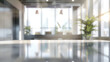 © Strother - Blurred modern office interior with a reflective tabletop in the foreground and bright window light, creating an abstract business background.