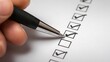 © dimas - Hand checking items off a list using a pen.