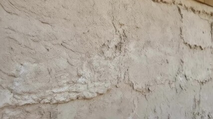 Poster - A medium closeup of an insulated wall section finished with a natural plaster displaying the texture and warmth of the biobased insulation beneath the smooth surface layer.