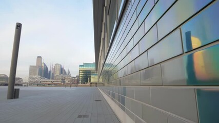 Poster - A medium closeup of glass tiles embedded with sensors displaying an iridescent sheen as they change color based on ambient temperature enhancing the buildings aesthetic appeal.