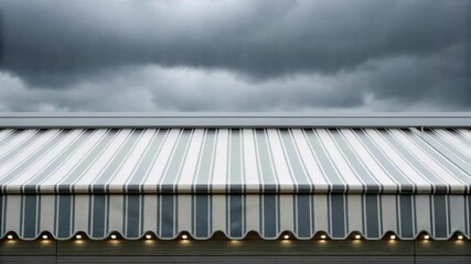Poster - Medium closeup of a system of retractable awnings stacked neatly along the edge of a building partially unfurling in response to sudden downpours glistening with moisture.