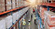 © Jessy25/peopleimages.com - Supplier, warehouse and employees walking for logistics, stock inventory or inspection by shelves. Above of industrial people, distribution and supply chain with safety, depot or wholesale storage