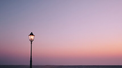 Poster - An ornate lamp post softly glows under a gradient sky transitioning from warm orange to deep violet. The setting captures the tranquility of dusk by the waterfront