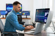 © New Africa - Financial trading specialist working on computer in office