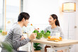 © anon - Asian couple  drinking milk and eating vegetable  breakfast  in kitchen at home .
