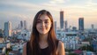 © Mey - A young woman with long brown hair stands in front of a city skyline at sunset.