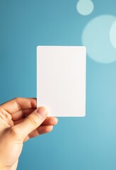 Poster - A hand holds a blank white card against a blue background with soft circular light effects