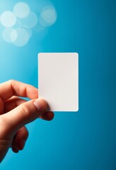 Poster - A hand holds a blank white card against a blue background with soft circular light effects