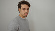 © Krakenimages.com - Handsome young hispanic man in casual attire gazing confidently at the camera against an isolated white background wall in a studio setting, exuding charm and personality