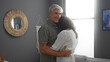 © Krakenimages.com - Middle-aged couple embraces in a cozy living room, showcasing love and connection, surrounded by stylish decor and a soothing atmosphere, highlighting relationship joy and comfort.