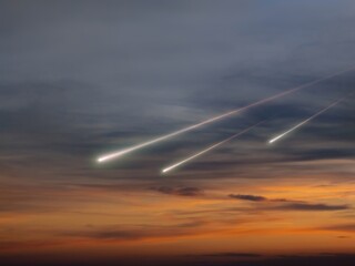 Wall Mural - meteors in the sky at sunset. fireballs with trails above the clouds. bright shooting stars isolated