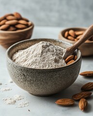 Poster - Almond flour in a bowl with almonds around, close up studio shot, healthy eating concept, gluten free alternative, baking ingredient