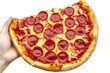 © Shanum - Hand holding a mouthwatering pepperoniladen pizza against a stark white backdrop