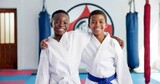 Hug, karate and portrait of friends in dojo for martial arts, self defense or sports training. Development, fitness and smile of student children embracing in class together for exercise or support