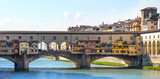 Ponte Vecchio spanning Arno River with colorful shops in Florence