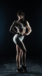 © vadim_fl - Young beautiful woman with athletic body on dark background. Fitness girl