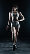 © vadim_fl - Young beautiful woman with athletic body on dark background. Fitness girl