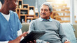 © FrameFlex/peopleimages.com - Old man, nurse and tablet in home for healthcare, medical support and test results. Retirement, senior patient and caregiver with technology in living room for help, checkup report and insurance app