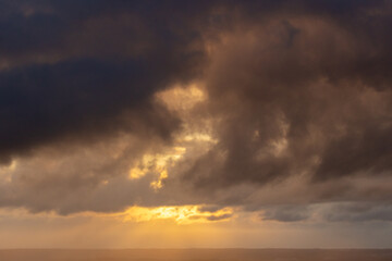 Wall Mural - Sky with Stormy Dark Dramatic Clouds at Sunset. Abstract Texture Background Pattern.