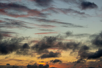 Wall Mural - Sky with Colorful Pink Golden and Dark Clouds at Evening Twilight. Abstract Texture Background Pattern.