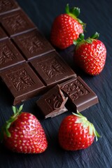 Poster - Chocolate bars and strawberries on black surface.