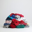 © khonkangrua - Pile of Colorful Crumpled Clothes on Simple Background for Textile Concepts