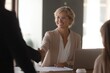© Zahra - Smiling businesswoman shaking hands with a client.  Successful meeting, positive business.