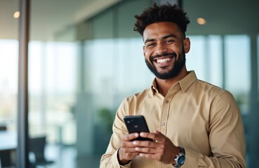 portrait of smiling businessman in office. black man holds phone, typing message. happy entrepreneur